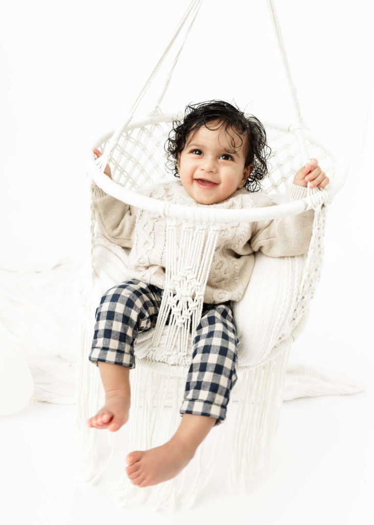 Baby in a Macrame Swing as a prop for a cake smash and milestone birthday photoshoot